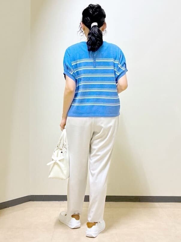 ブルー系のニット/セーター、ベージュ系のその他パンツ、ホワイト系のトートバッグを着用したレディースの夏コーディネートの3枚目の写真