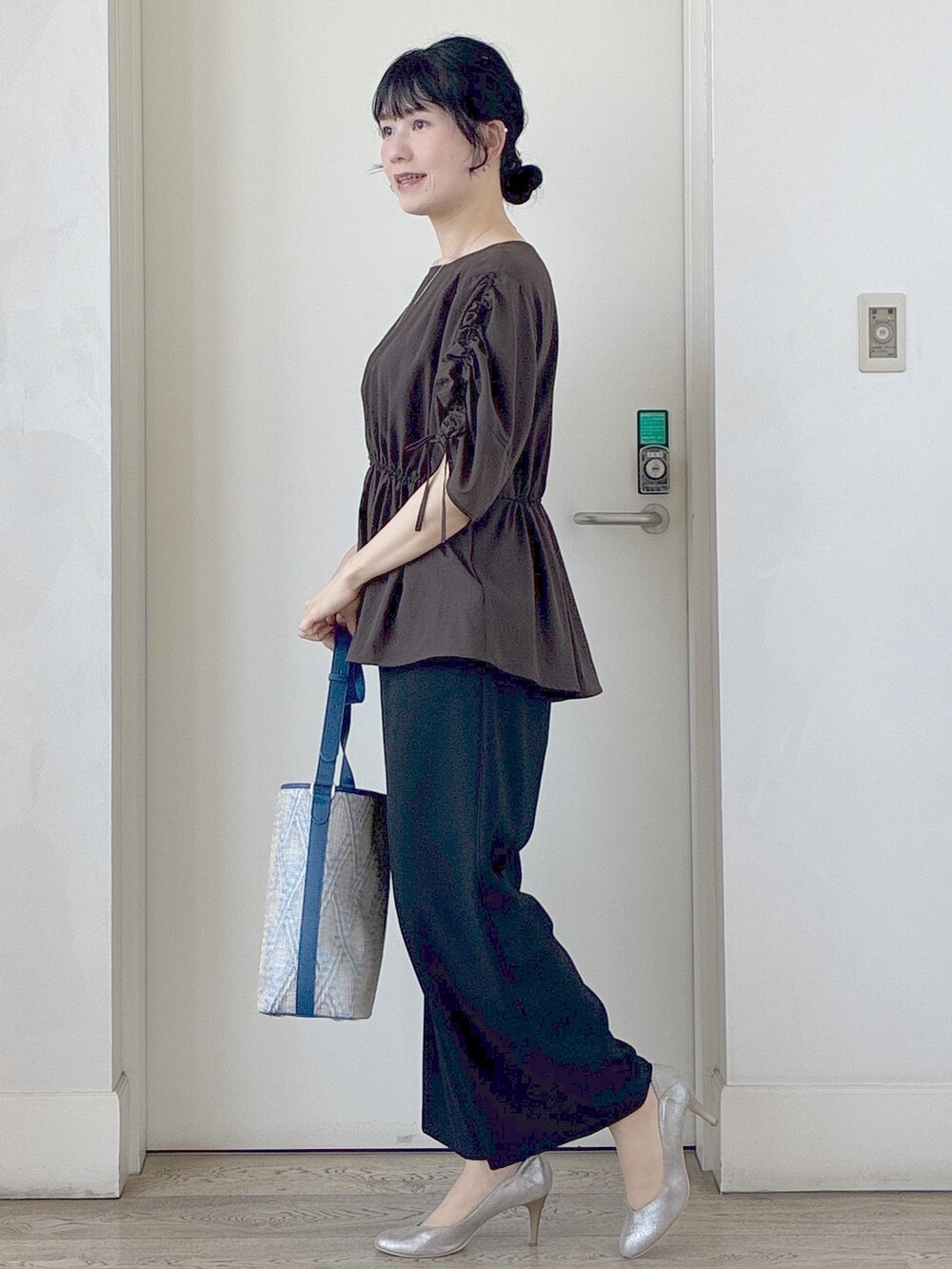 ブラック系のその他パンツ、ブルー系のショルダーバッグ、ホワイト系のカーディガン/ボレロを着用したレディースの春コーディネートの2枚目の写真