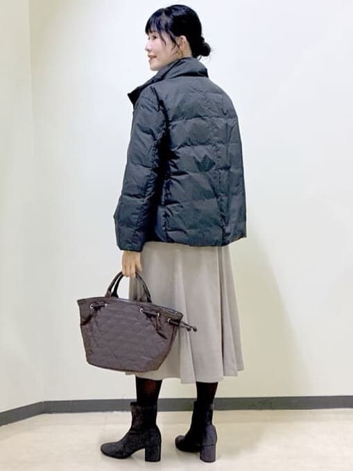 レッド系のニット/セーター、ベージュ系のスカート、ブラック系のダウンジャケット/コートを着用したレディースの秋コーディネートの10枚目の写真