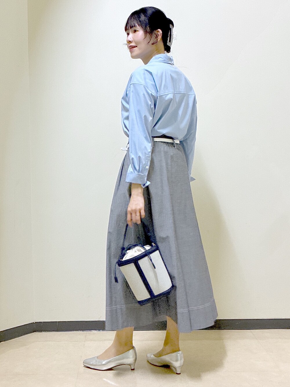 ブルー系のシャツ/ブラウス、ブルー系のニット/セーター、ブラック系のスカートを着用したレディースの春コーディネートの4枚目の写真
