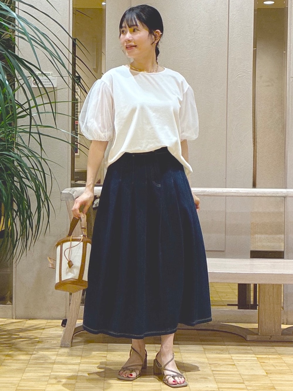 ホワイト系のTシャツ/カットソー、ブルー系のデニムスカート、グレー系のカーディガン/ボレロを着用したレディースの夏コーディネートの4枚目の写真