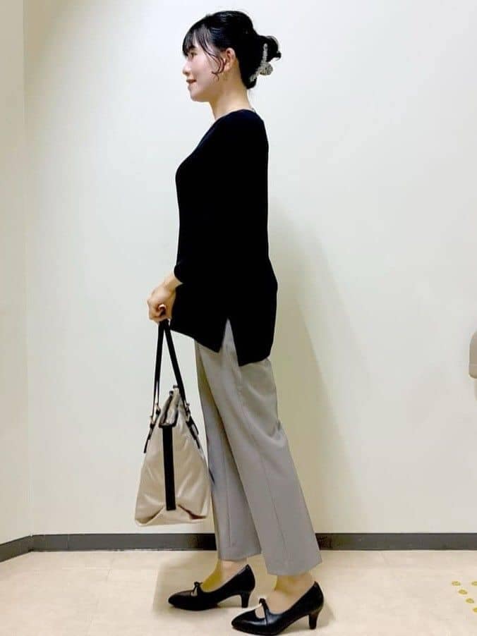 ブルー系のニット/セーター、ブラウン系のその他パンツ、ベージュ系のトートバッグを着用したレディースの春コーディネートの2枚目の写真