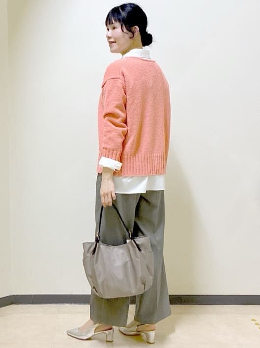 オレンジ系のニット/セーター、ホワイト系のシャツ/ブラウス、ベージュ系のその他パンツを着用したレディースの春コーディネートの4枚目の写真