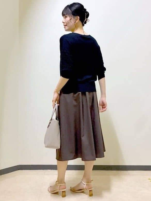 ブラック系のニット/セーター、ベージュ系のスカート、ブラウン系のスカートを着用したレディースの夏コーディネートの10枚目の写真