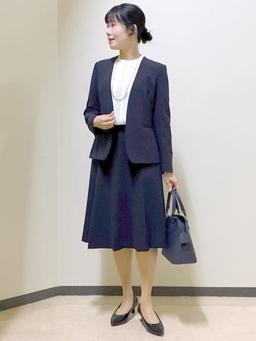 ブルー系のノーカラージャケット、ホワイト系のシャツ/ブラウス、ブルー系のスカートを着用したレディースの冬コーディネートの8枚目の写真