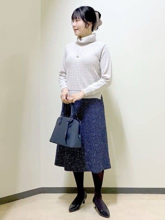 グレー系のニット/セーター、ブルー系のスカート、ブルー系のハンドバッグを着用したレディースの冬コーディネートの7枚目の写真