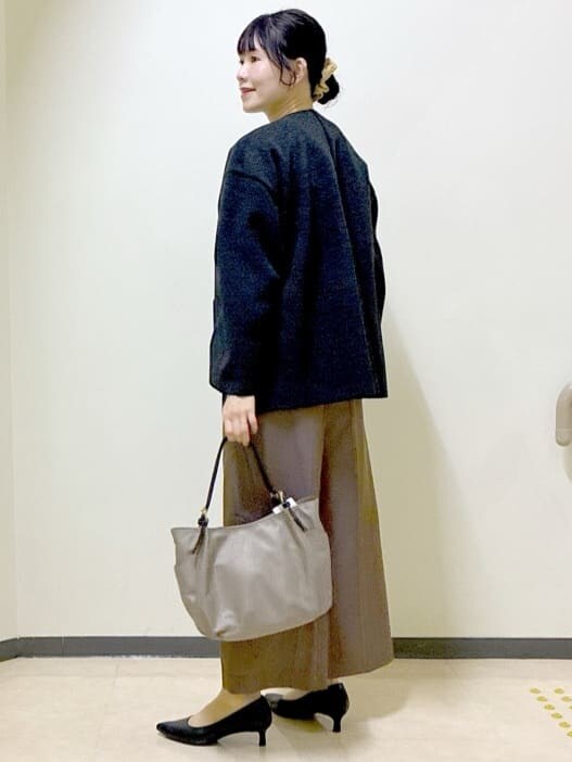 グレー系のノーカラーコート、ホワイト系のニット/セーター、ブラウン系のその他パンツを着用したレディースの冬コーディネートの4枚目の写真