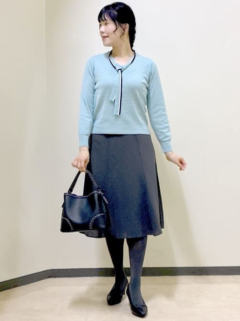 ブルー系のノーカラージャケット、ブルー系のニット/セーター、グレー系のスカートを着用したレディースの秋コーディネートの9枚目の写真