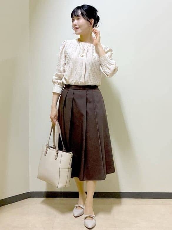 ベージュ系のシャツ/ブラウス、ブラウン系のスカート、ベージュ系のトートバッグを着用したレディースの春コーディネートの7枚目の写真