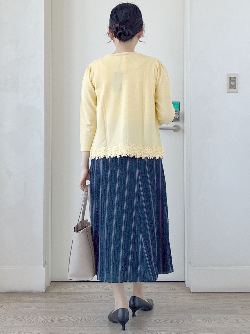 イエロー系のカーディガン/ボレロ、ホワイト系のシャツ/ブラウス、ブルー系のスカートを着用したレディースの春コーディネートの3枚目の写真