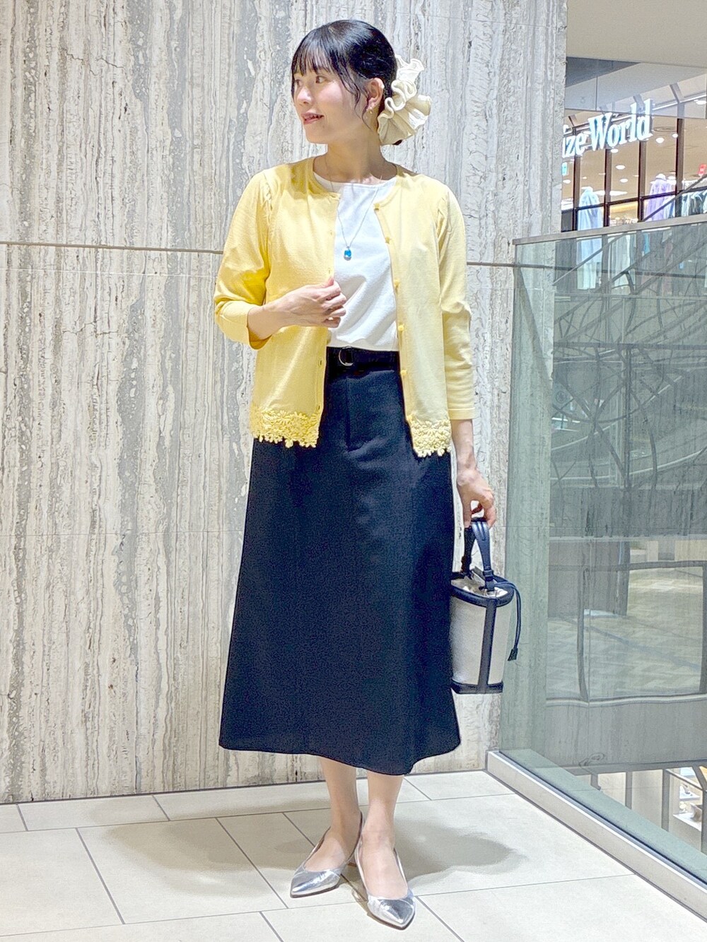 イエロー系のカーディガン/ボレロ、ホワイト系のTシャツ/カットソー、ブルー系のスカートを着用したレディースの夏コーディネートの5枚目の写真
