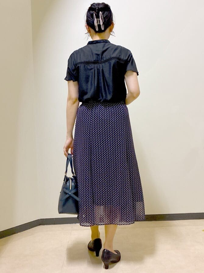 ブラック系のシャツ/ブラウス、ブルー系のスカート、グレー系のカーディガン/ボレロを着用したレディースの夏コーディネートの3枚目の写真