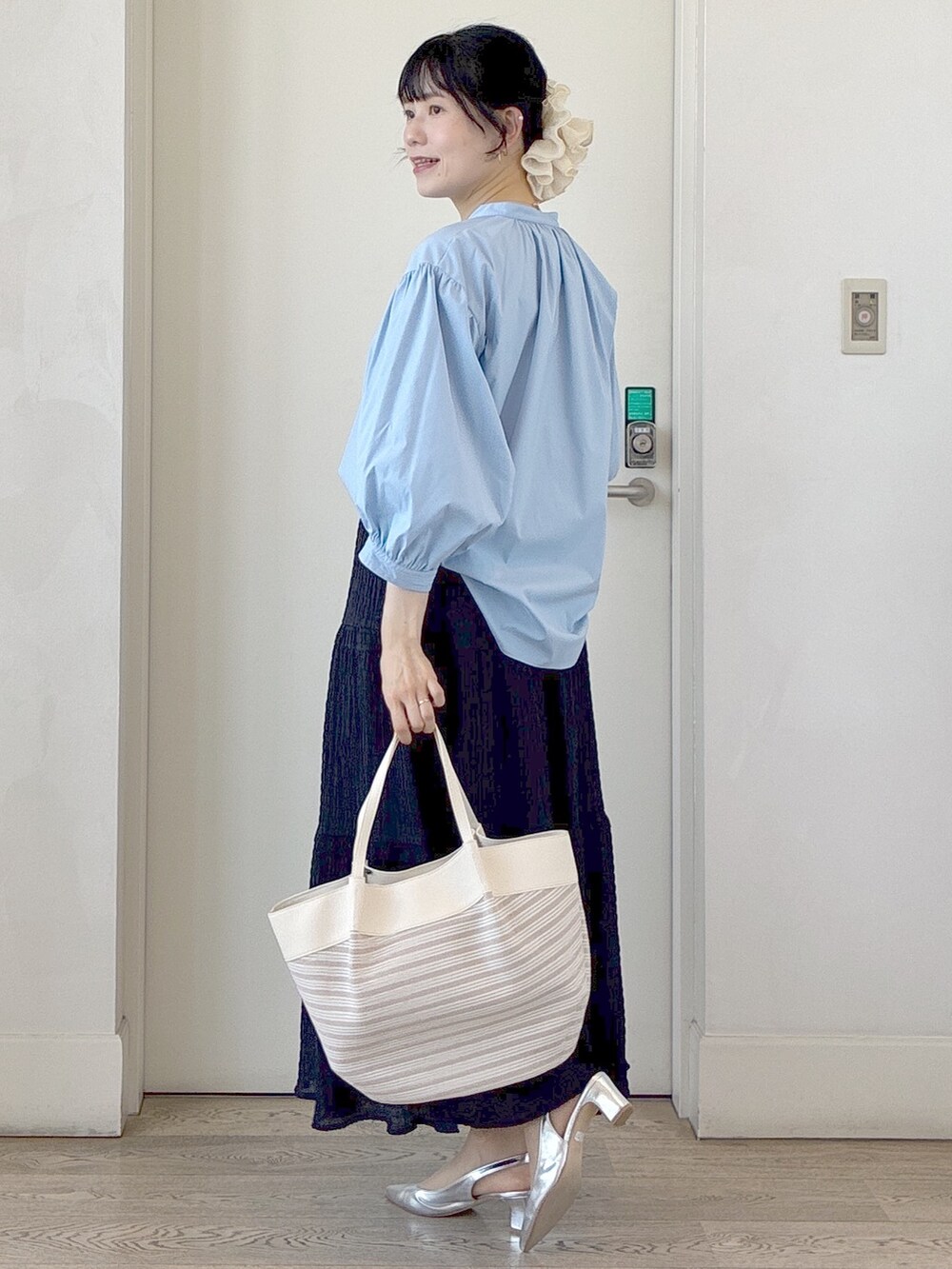 ブルー系のシャツ/ブラウス、ベージュ系のトートバッグ、ベージュ系のタンクトップを着用したレディースの春コーディネートの4枚目の写真