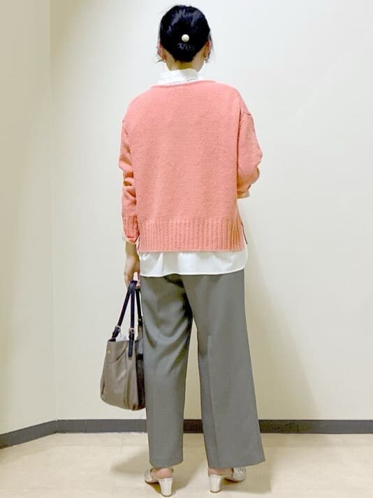 オレンジ系のニット/セーター、ホワイト系のシャツ/ブラウス、ベージュ系のその他パンツを着用したレディースの春コーディネートの3枚目の写真