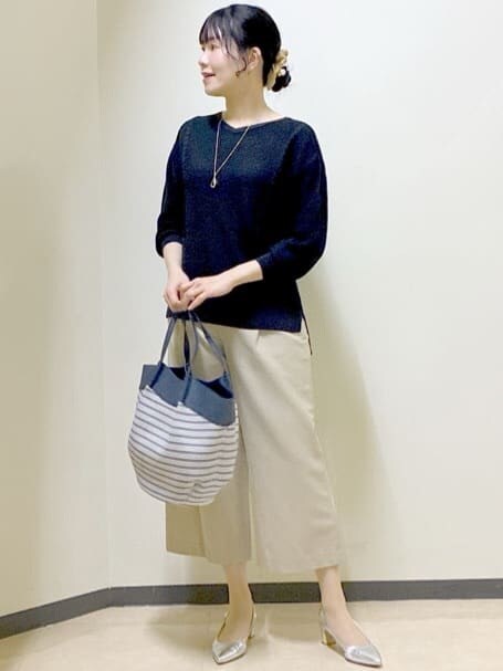 ベージュ系のその他パンツ、ブラック系のニット/セーター、ブルー系のトートバッグを着用したレディースの春コーディネートの6枚目の写真