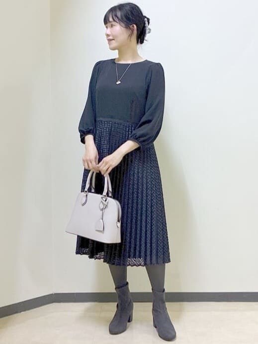 ブルー系のワンピース、グレー系のチェスターコート、ベージュ系のハンドバッグを着用したレディースの冬コーディネートの6枚目の写真