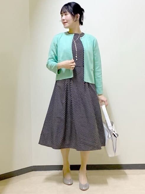 ベージュ系のワンピース、グリーン系のカーディガン/ボレロ、ホワイト系のトートバッグを着用したレディースの春コーディネートの7枚目の写真