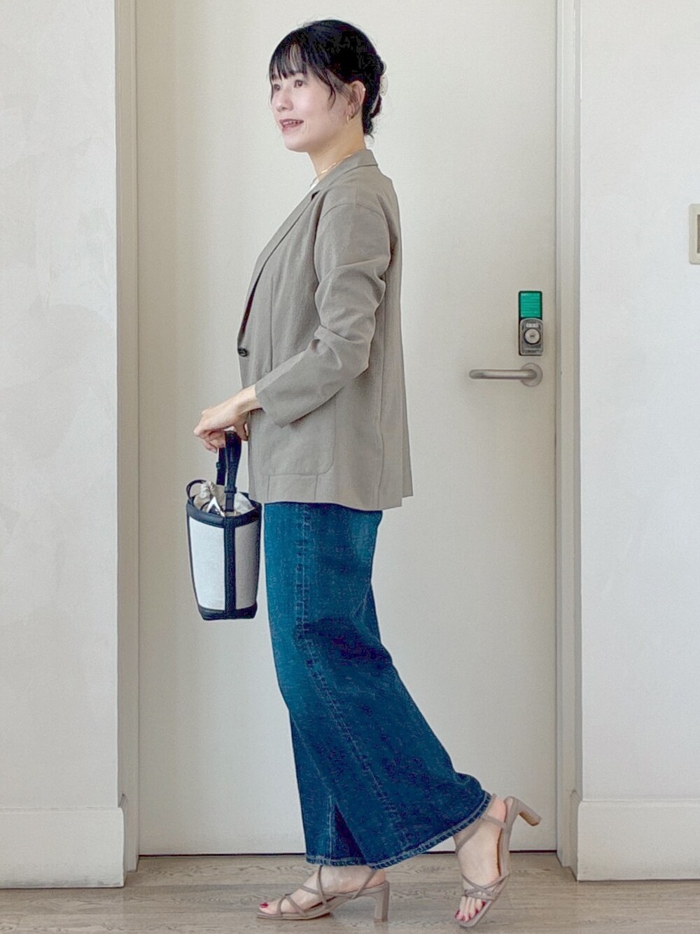 グリーン系のテーラードジャケット、ホワイト系のTシャツ/カットソー、ブルー系のデニムパンツを着用したレディースの夏コーディネートの2枚目の写真