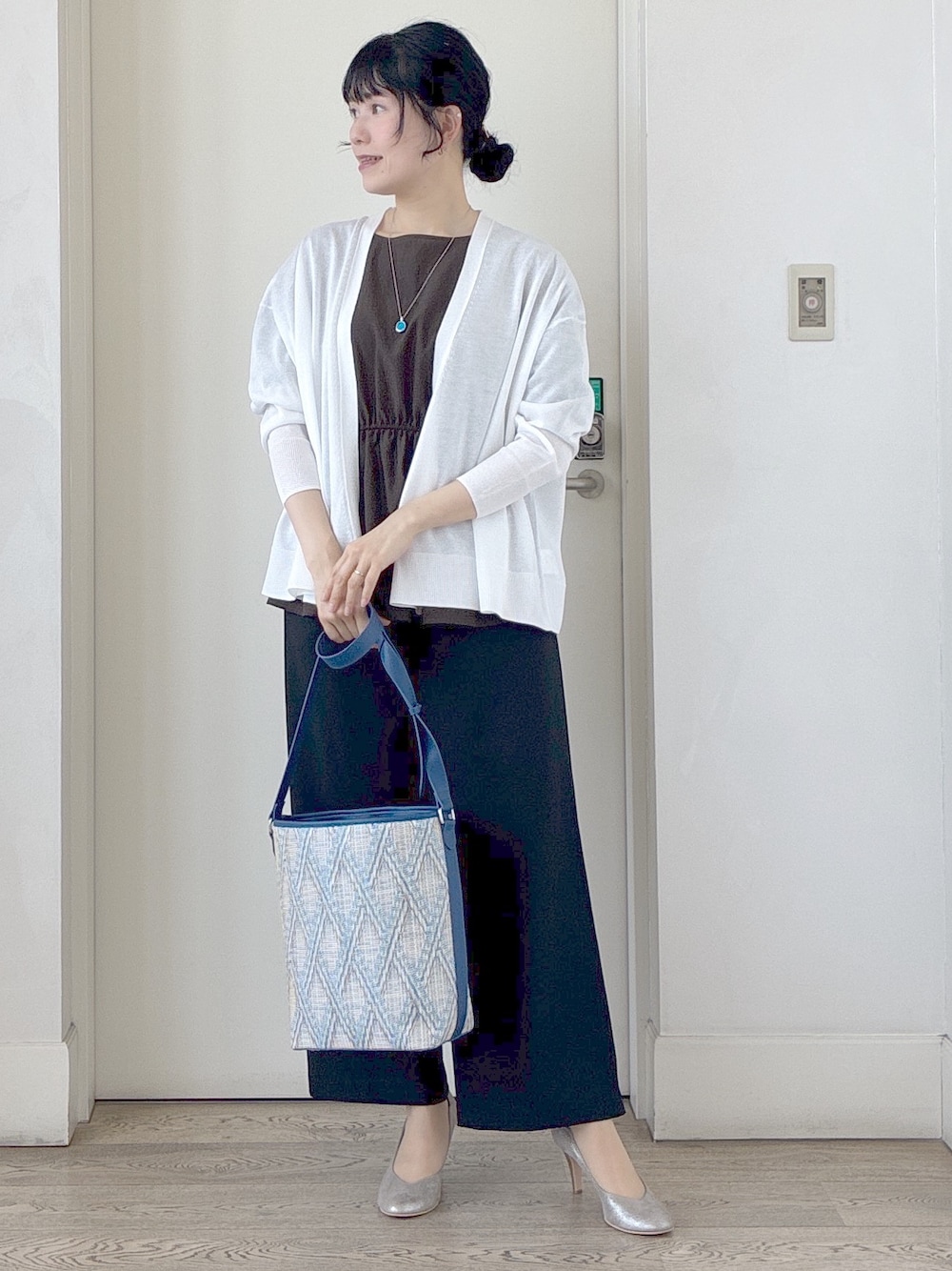 ブラック系のその他パンツ、ブルー系のショルダーバッグ、ホワイト系のカーディガン/ボレロを着用したレディースの春コーディネートの6枚目の写真