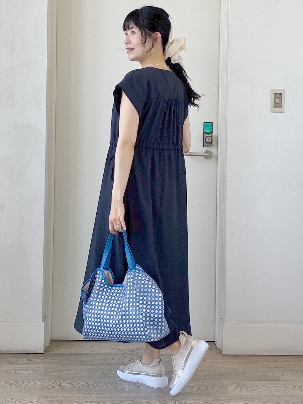 ブルー系のワンピース、ベージュ系のタンクトップ、ブルー系のブルゾンを着用したレディースの春コーディネートの4枚目の写真