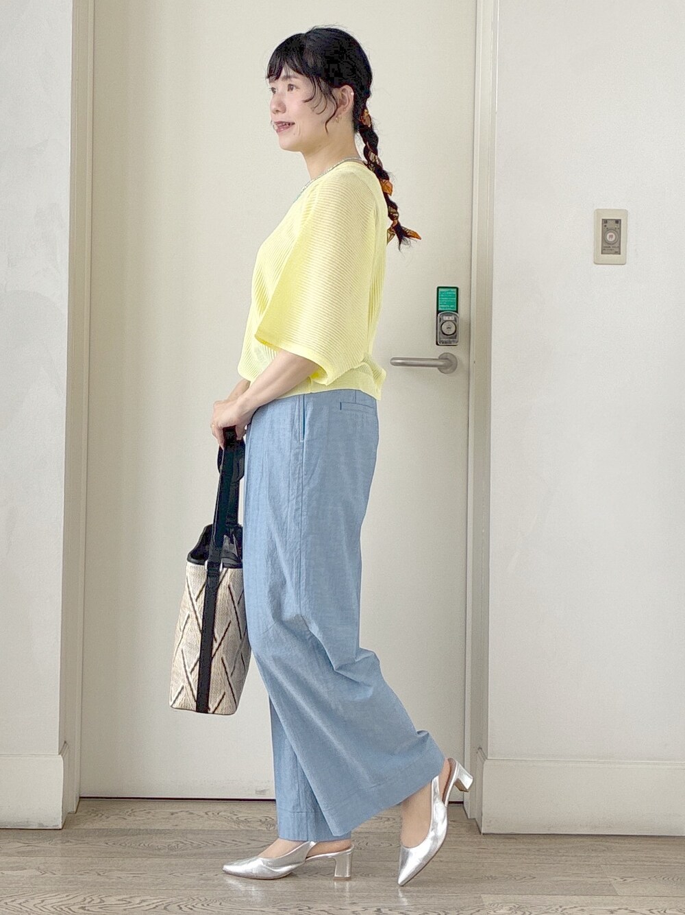 ブルー系のその他パンツ、ベージュ系のショルダーバッグ、イエロー系のニット/セーターを着用したレディースの春コーディネートの2枚目の写真