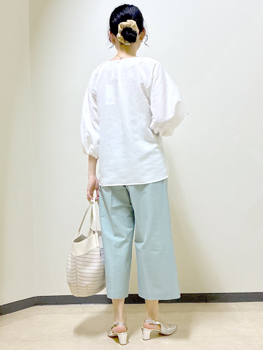 ホワイト系のシャツ/ブラウス、グリーン系のその他パンツ、ベージュ系のトートバッグを着用したレディースの春コーディネートの3枚目の写真