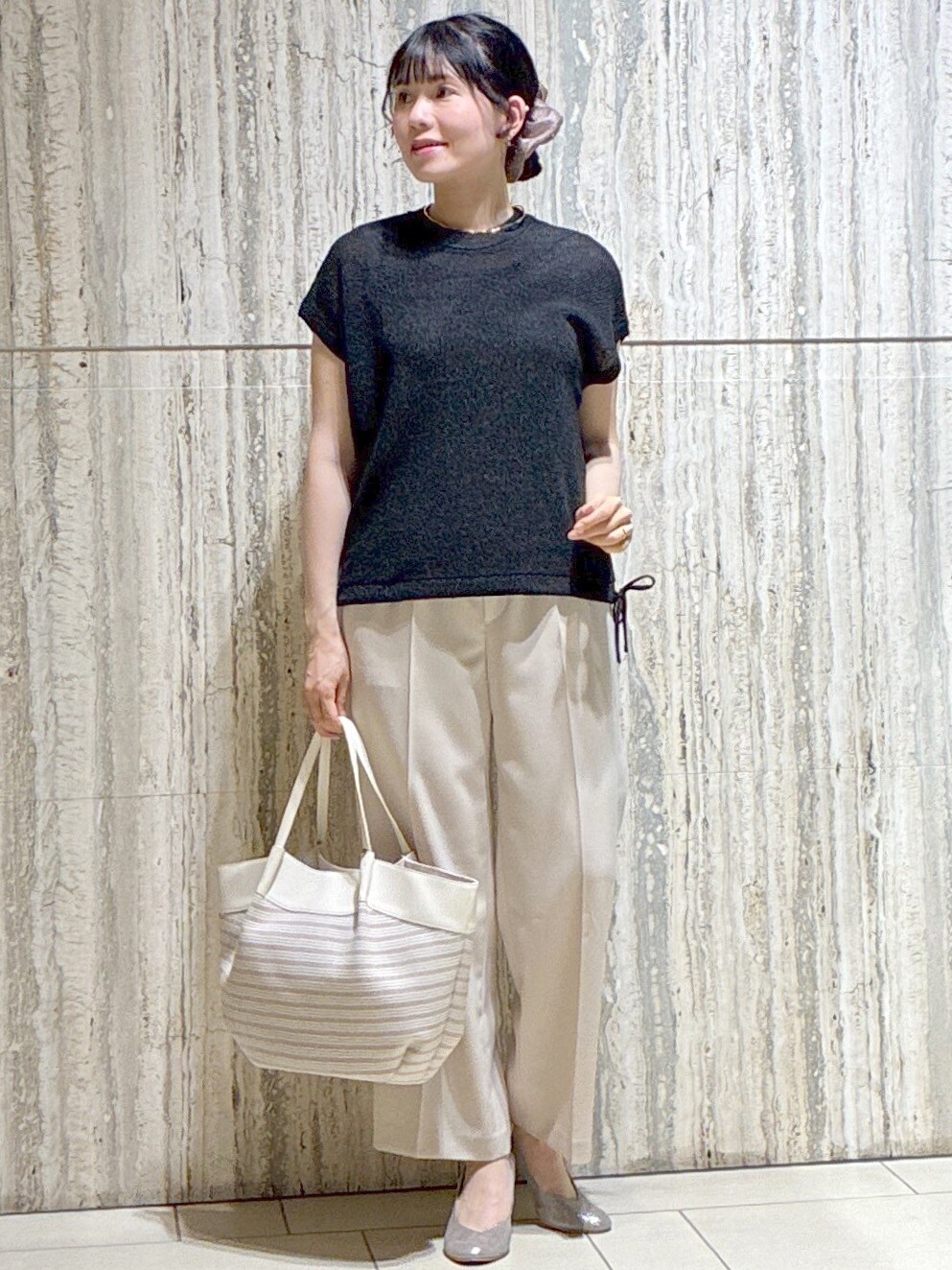 ブラック系のニット/セーター、ベージュ系のその他パンツ、ベージュ系のトートバッグを着用したレディースの夏コーディネートの8枚目の写真
