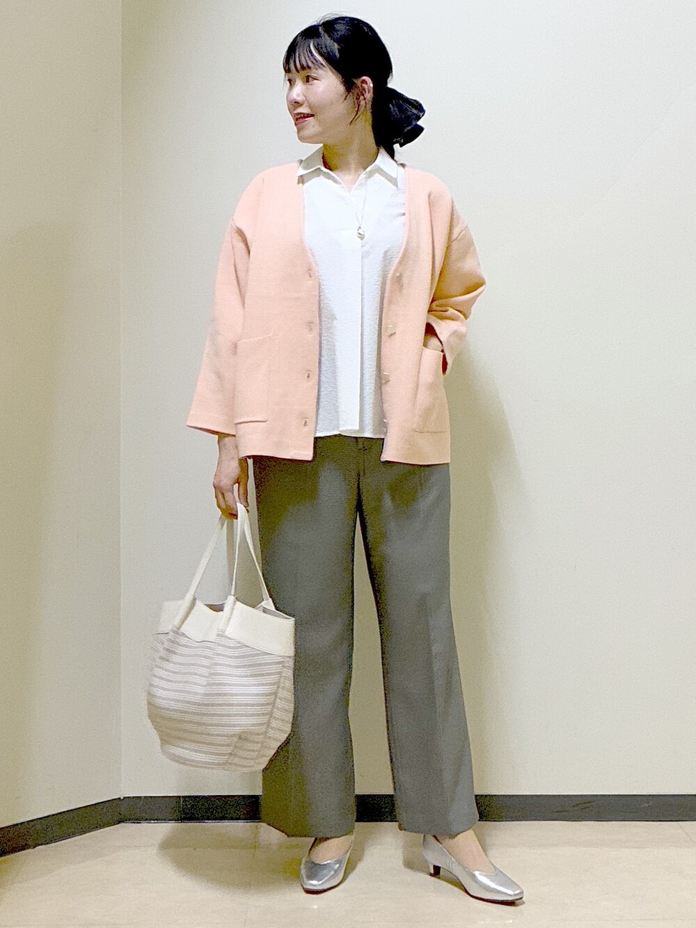 ホワイト系のシャツ/ブラウス、オレンジ系のカーディガン/ボレロ、ベージュ系のその他パンツを着用したレディースの春コーディネートの9枚目の写真