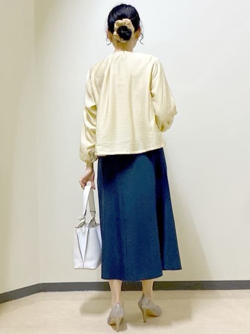 ベージュ系のブルゾン、ブルー系のスカート、ホワイト系のトートバッグを着用したレディースの春コーディネートの3枚目の写真