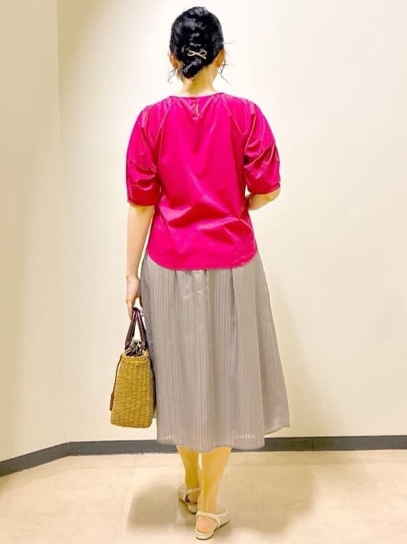 レッド系のTシャツ/カットソー、グリーン系のスカート、イエロー系のトートバッグを着用したレディースの夏コーディネートの3枚目の写真