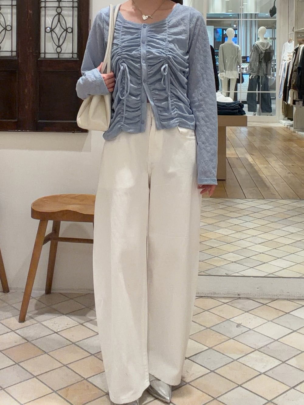 ブルー系のカーディガン/ボレロ、ベージュ系のトレンチコート、ホワイト系のデニムパンツを着用したレディースの春コーディネートの3枚目の写真