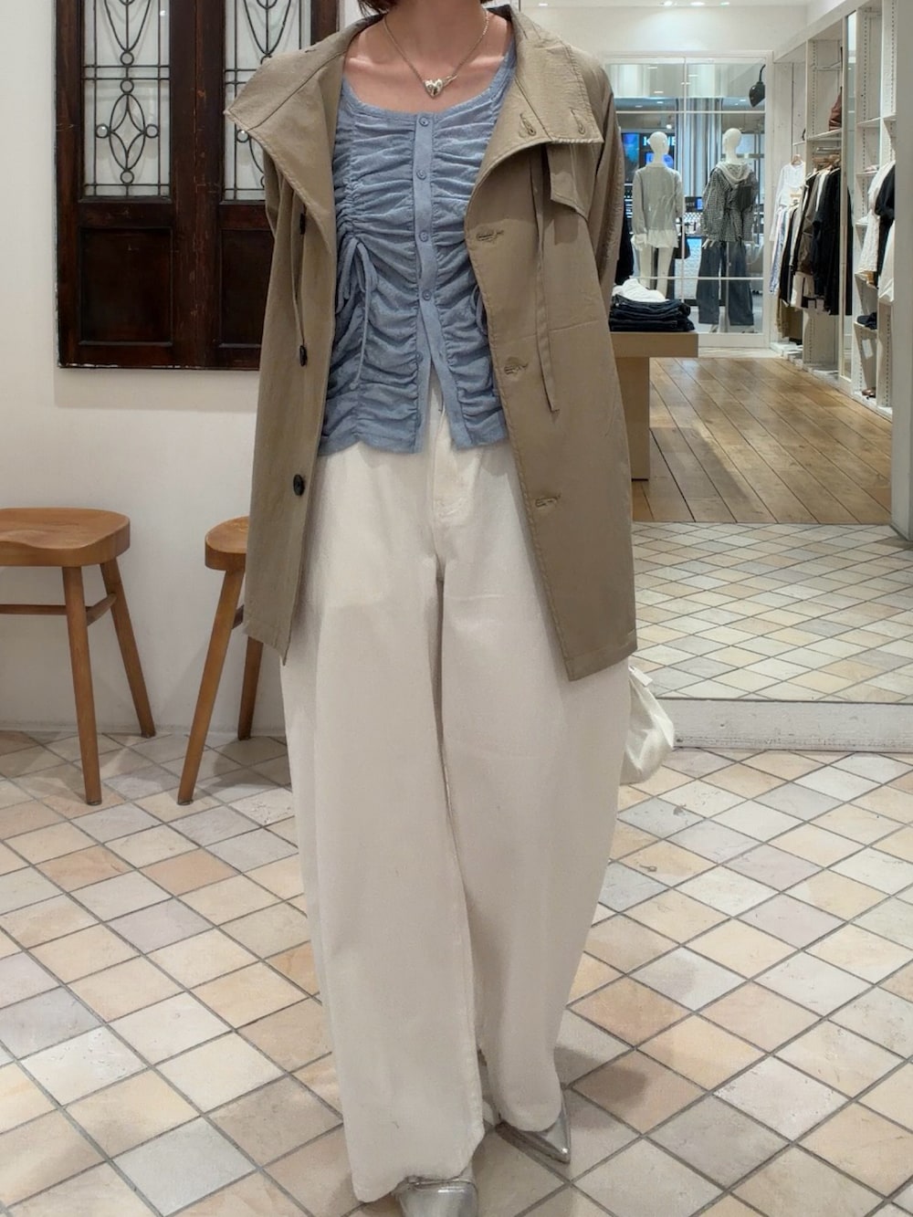 ブルー系のカーディガン/ボレロ、ベージュ系のトレンチコート、ホワイト系のデニムパンツを着用したレディースの春コーディネートの2枚目の写真