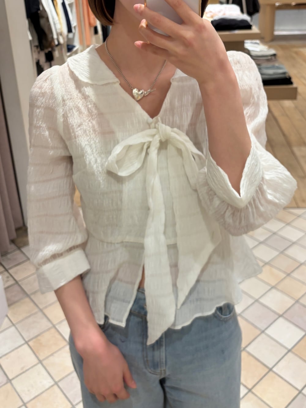 ベージュ系のトレンチコート、ホワイト系のシャツ/ブラウス、ブラック系のトートバッグを着用したレディースの春コーディネートの4枚目の写真