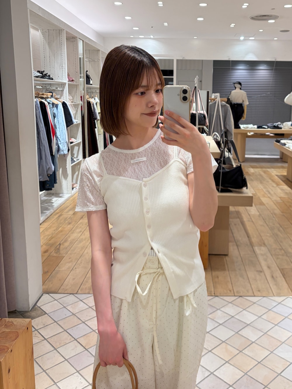 ホワイト系のキャミソール、ホワイト系のTシャツ/カットソー、ホワイト系のスラックスを着用したレディースの春コーディネートの3枚目の写真