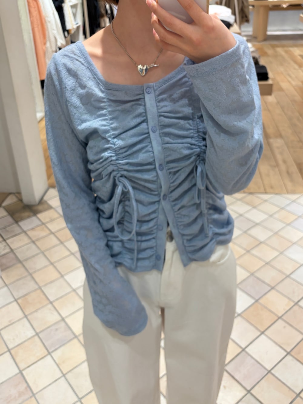 ブルー系のカーディガン/ボレロ、ベージュ系のトレンチコート、ホワイト系のデニムパンツを着用したレディースの春コーディネートの5枚目の写真