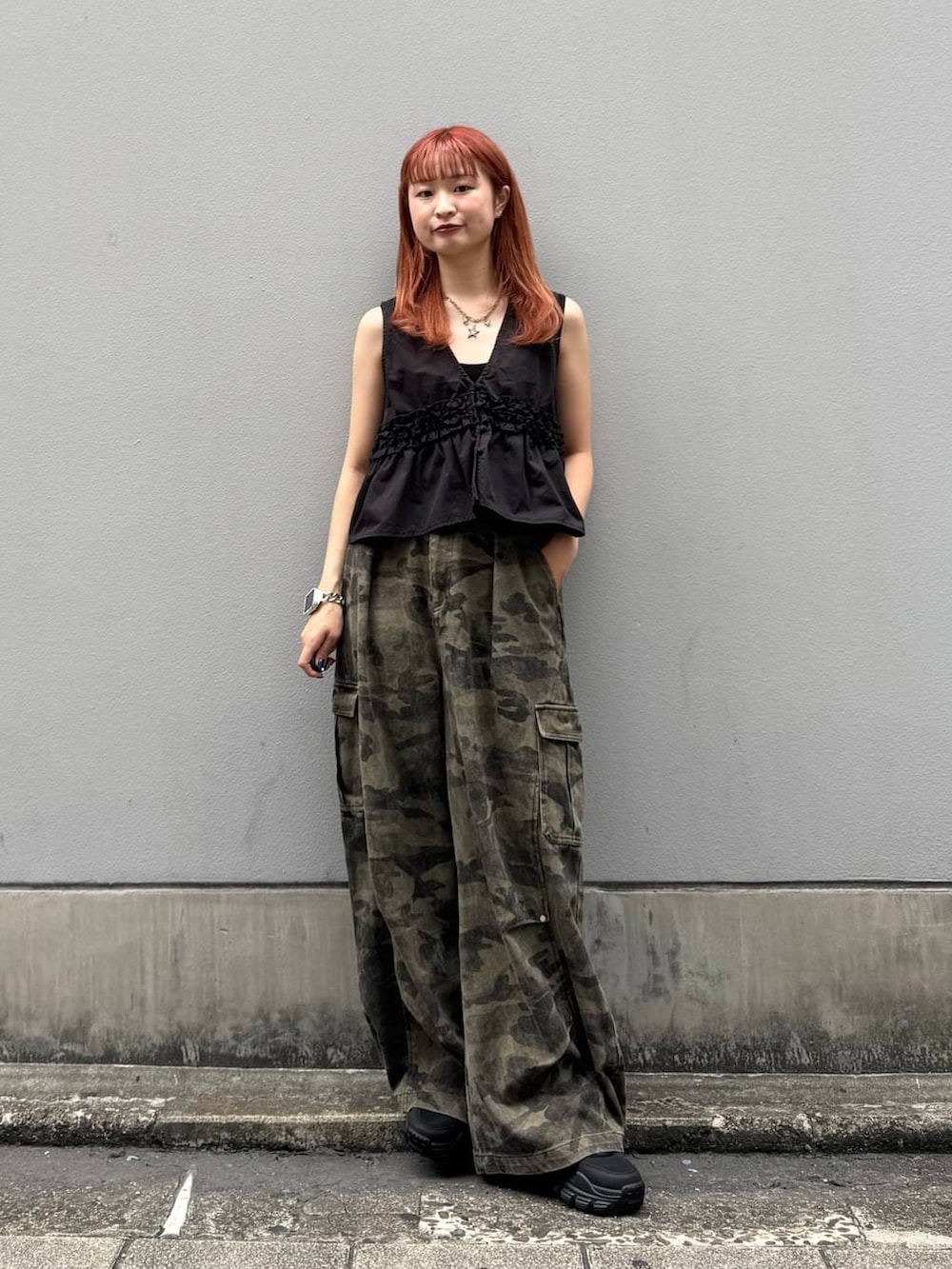 グリーン系のカーゴパンツ、ブラック系のタンクトップ、ブラック系のサンダルを着用したレディースの夏コーディネートの3枚目の写真