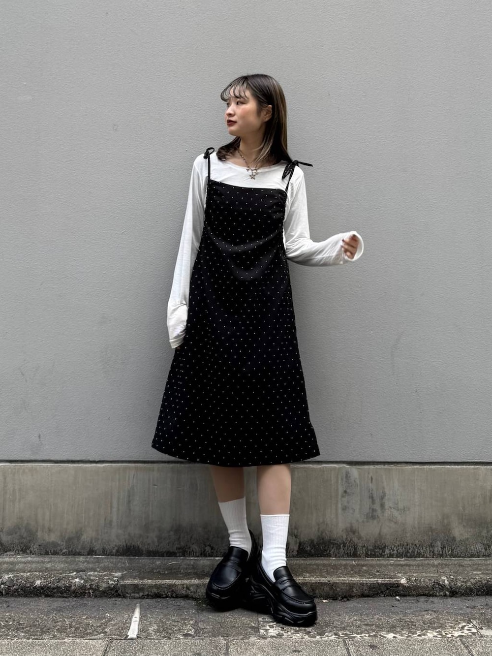 ブラック系のローファー、ブラック系のワンピース、ホワイト系のTシャツ/カットソーを着用したレディースの春コーディネートの2枚目の写真