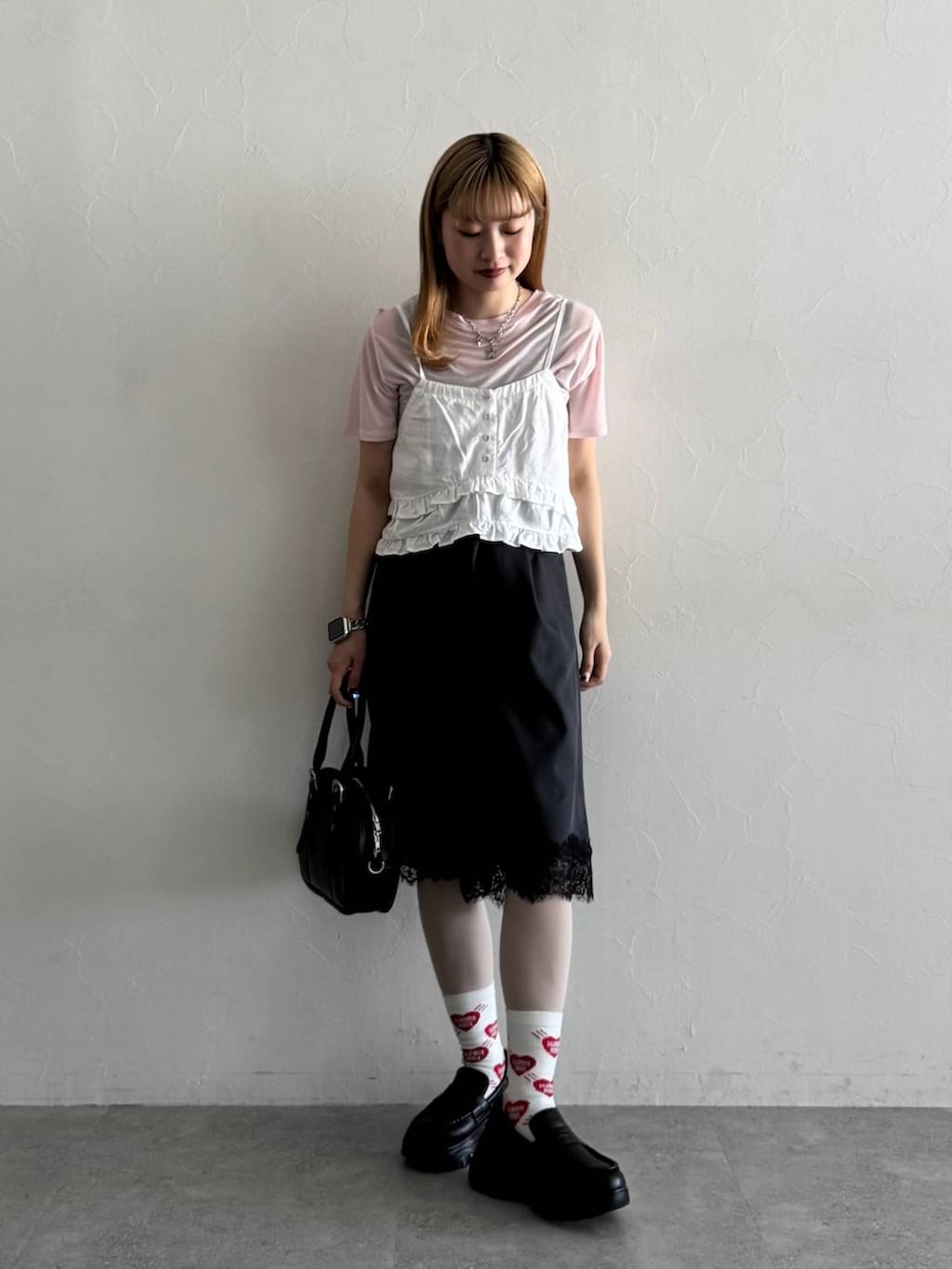 ブラック系のローファー、ブラック系のボストンバッグ、ピンク系のTシャツ/カットソーを着用したレディースの春コーディネートの2枚目の写真