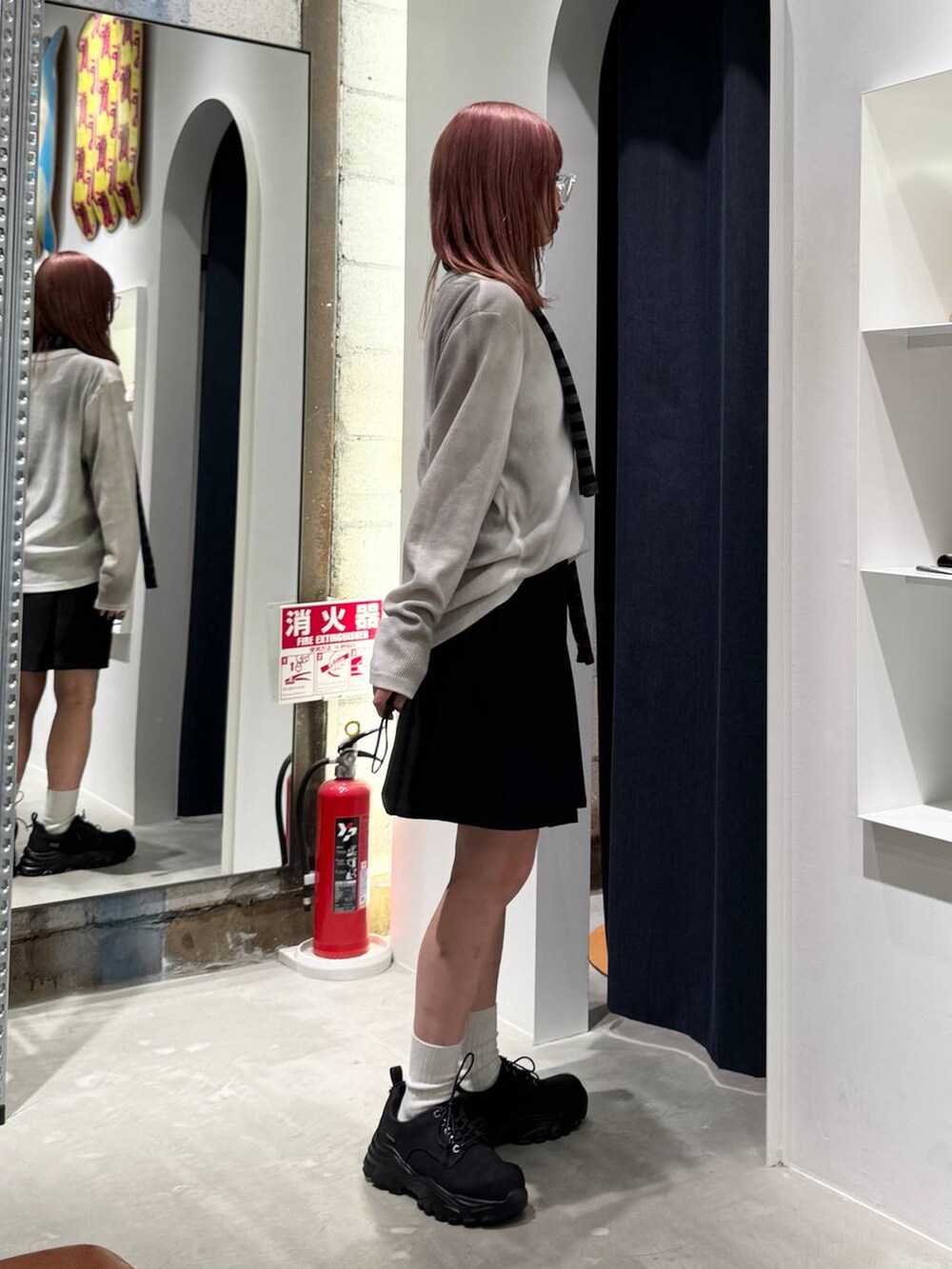 ブラック系のブーツ、ホワイト系のTシャツ/カットソー、ブラック系のニット/セーターを着用したレディースの秋コーディネートの7枚目の写真
