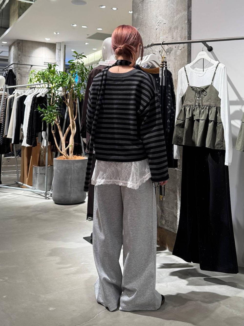 ホワイト系のTシャツ/カットソー、ブラック系のニット/セーター、グレー系のスウェットパンツを着用したレディースの秋コーディネートの7枚目の写真