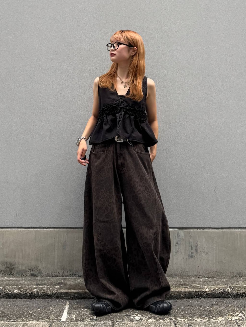 ブラウン系のデニムパンツ、ブラック系のベスト、ブラック系のベルトを着用したレディースの夏コーディネートの5枚目の写真