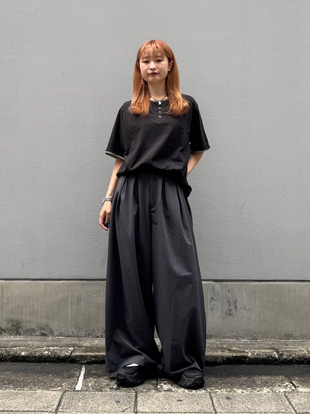 ブラック系のTシャツ/カットソー、グレー系のスラックス、ブラック系のサンダルを着用したレディースの夏コーディネートの4枚目の写真