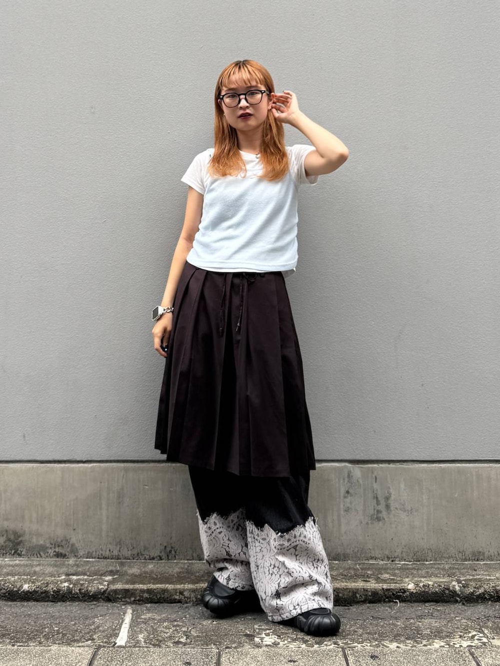 ブラウン系のスカート、ブラック系のデニムパンツ、ホワイト系のTシャツ/カットソーを着用したレディースの秋コーディネートの4枚目の写真