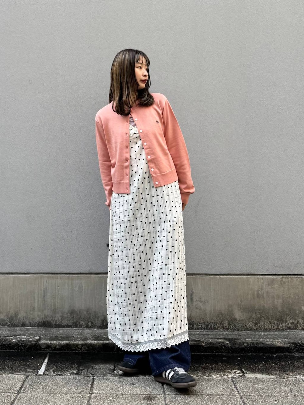 ブルー系のデニムパンツ、ホワイト系のワンピース、ピンク系のTシャツ/カットソーを着用したレディースの春コーディネートの3枚目の写真