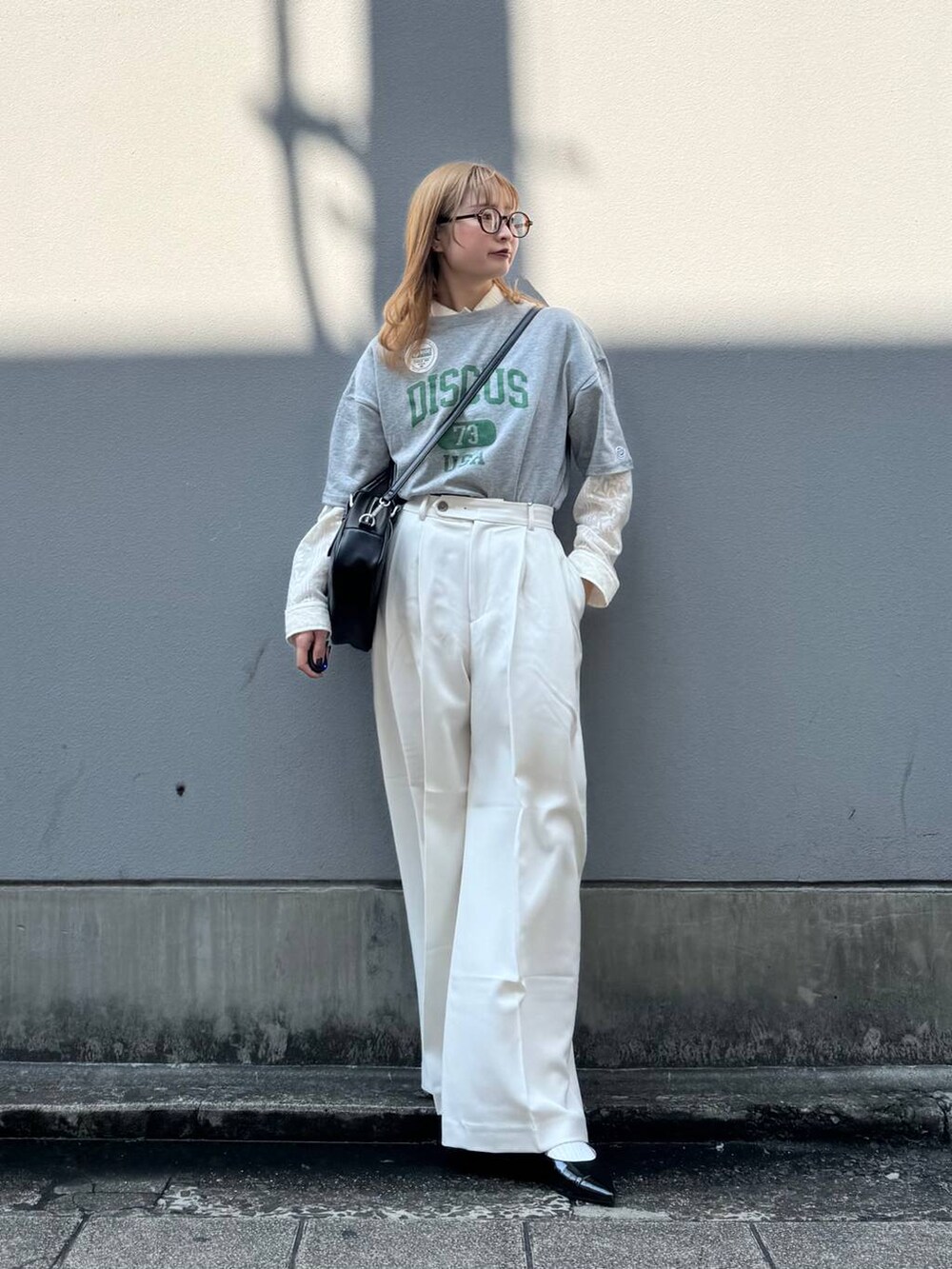 グレー系のTシャツ/カットソー、ブラック系のパンプス、ホワイト系のシャツ/ブラウスを着用したレディースの春コーディネートの4枚目の写真