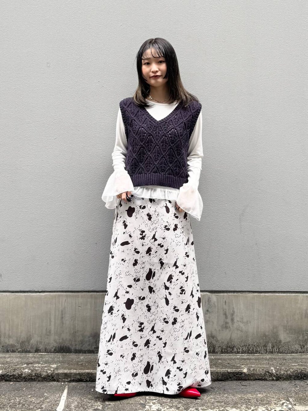 レッド系のパンプス、ブラウン系のスカート、ホワイト系のTシャツ/カットソーを着用したレディースの春コーディネートの3枚目の写真