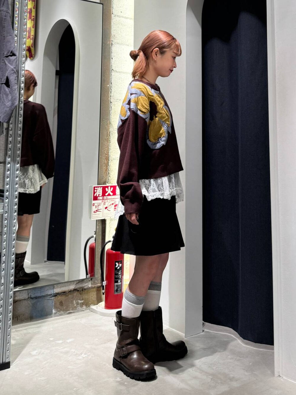 ホワイト系のTシャツ/カットソー、ブラウン系のニット/セーター、ブラック系のスカートを着用したレディースの秋コーディネートの7枚目の写真