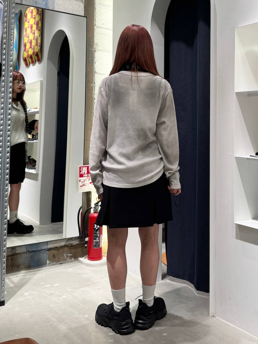 ブラック系のブーツ、ホワイト系のTシャツ/カットソー、ブラック系のニット/セーターを着用したレディースの秋コーディネートの6枚目の写真