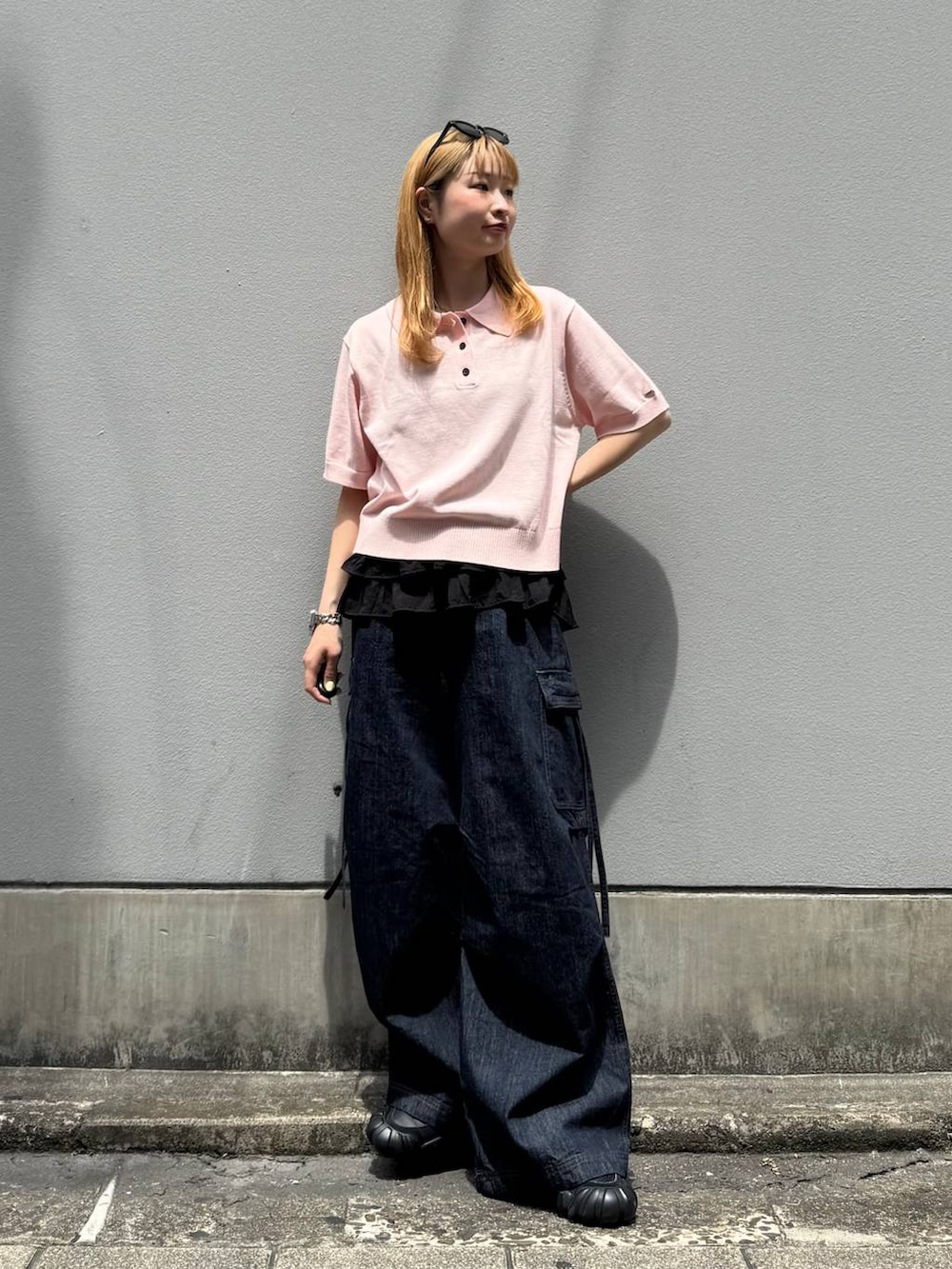 ピンク系のポロシャツ、ブルー系のデニムパンツ、グレー系のタンクトップを着用したレディースの夏コーディネートの3枚目の写真