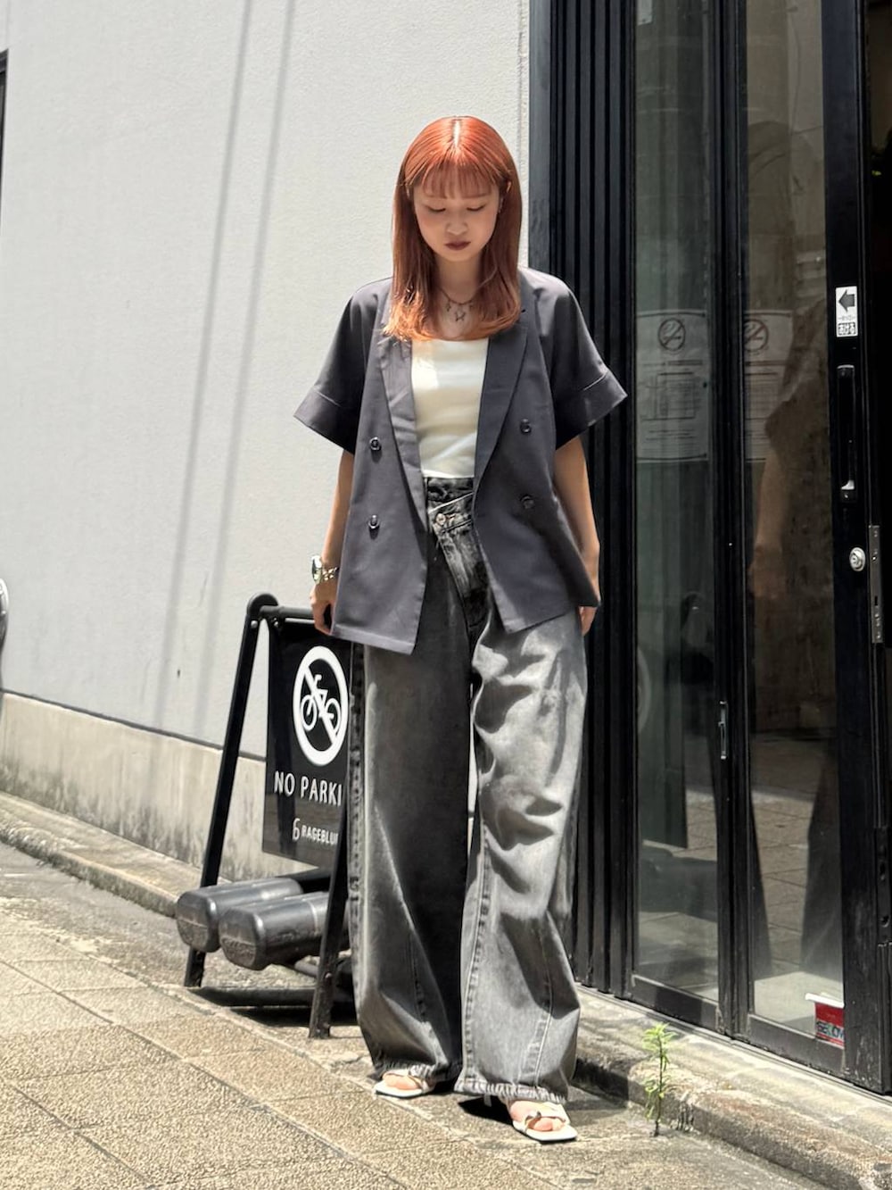グレー系のデニムパンツ、グレー系のテーラードジャケット、ホワイト系のキャミソールを着用したレディースの夏コーディネートの2枚目の写真